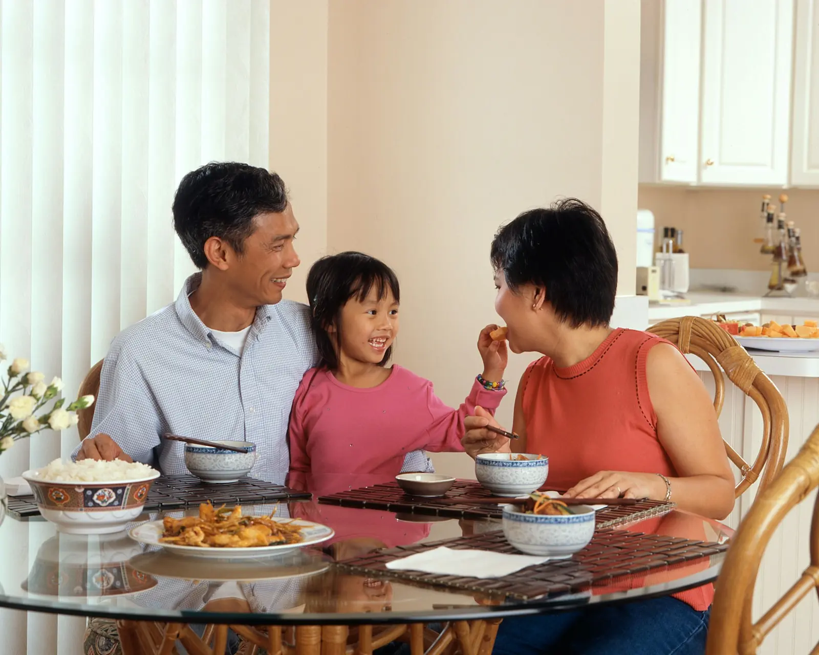A family laughing together over a meal at the table